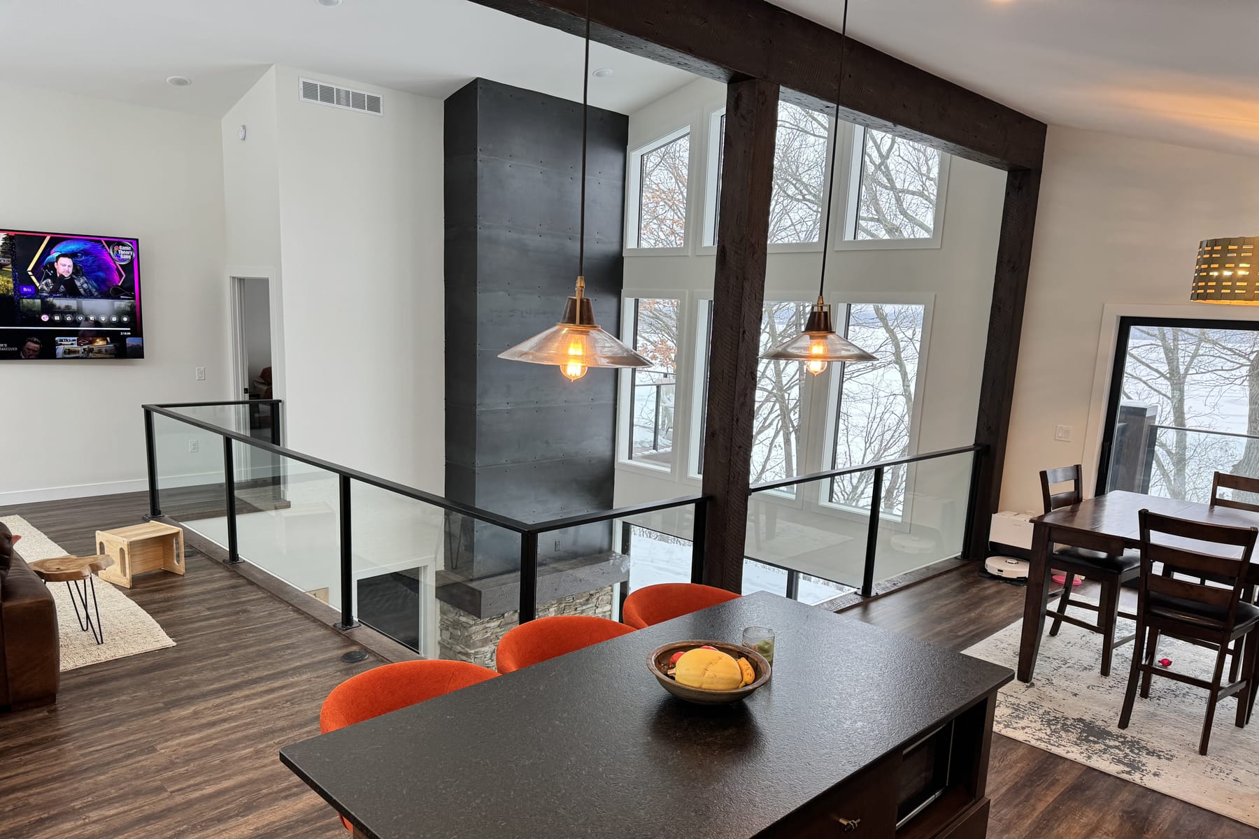 Interior: vaulted ceiling carried on heavy dark timber beams, with a blackened-steel fireplace surround.
