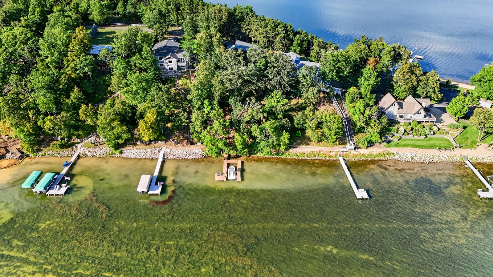 Hunters Point from the air, the wooded shoreline and the docks along Wilson Bay.